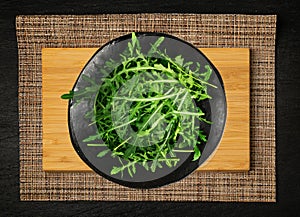 Arugula on Black Plate, Fresh Arugula, Ruccola Leaves, Rucola, Eruca or Garden Roquette Salad