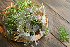 Arugula. Fresh leaves arugula salad on wooden bowl on old wooden table background. Arugula is source of vitamins and trace eleme