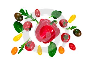 Arugula leaves, cherry tomatoes of different colors and basil around a bell red pepper isolated on white