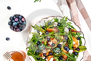 Arugula and peaches salad. Vegetarian gourmet salad made of caramelized grilled peaches slices, arugula leaves, goat cheese on a