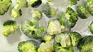 As clear water flows over the broccoli, it accentuates the freshness of these lush greens, highlighting the importance