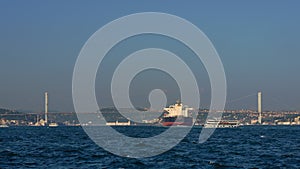 As an oil tanker advances through the Bosphorus Strait, its enormity contrasts with the narrow waterway, marking a vital