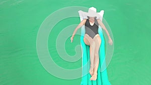 As relaxed as relaxing gets. 4k video footage of a young woman relaxing on an inflatable lounger while floating on the