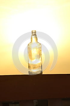 As the sun bids adieu to the day, be enchanted by the ethereal silhouette of a glass bottle against the backdrop of a dreamy sunse