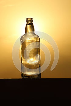 As the sun bids adieu to the day, be enchanted by the ethereal silhouette of a glass bottle against the backdrop of a dreamy sunse