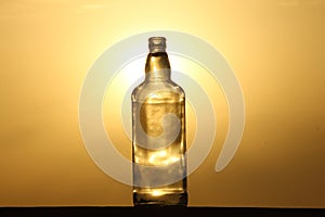 As the sun bids adieu to the day, be enchanted by the ethereal silhouette of a glass bottle against the backdrop of a dreamy sunse