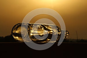 As the sun bids adieu to the day, be enchanted by the ethereal silhouette of a glass bottle against the backdrop of a dreamy sunse