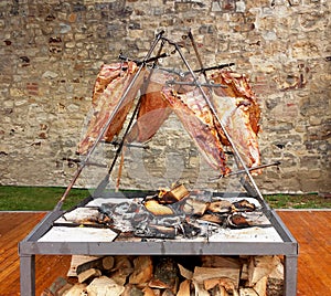 Asado roast barbecue meat on fire, traditional dish in Argentina, Uruguay, Paraguay, Chile, and Brazil photo