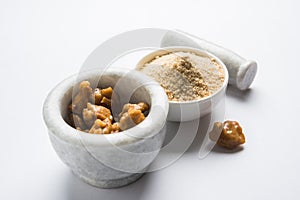 Stock Photo of Asafoetida powder / Hing or Heeng with cake and mortar