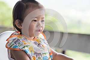 Asain cute baby girl eatting ice water on white chair.