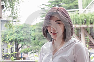 Asain girl`s short hair smiling and looking emotion in the nature garden background