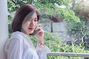 Asain girl`s smiling and using smart phone , happy time and taking mobile telephone