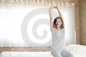 Asain girl stretching in bed