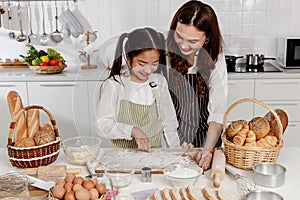 Asain mother and daughter worked together to finish the baking and kneading the dough, and the daughter write the heart love on