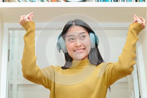 Asain woman in headphones enjoying music