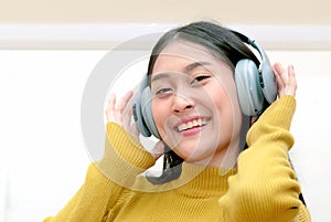 Asain woman in headphones enjoying music