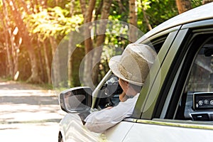 Asain woman traveler take a photo with hatchback car to travel on the road forest.