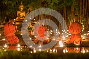 Asalha Puja Day ,Monks pray to buddha statue .