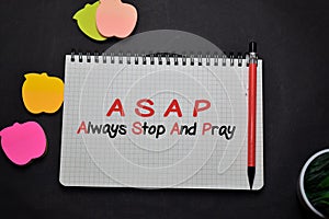 ASAP - Always Stop And Pray write on a book  on office desk. Christian faith concept