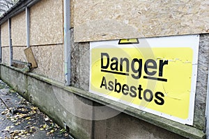 Asbestos danger sign at building construction site refurbishment of old building photo