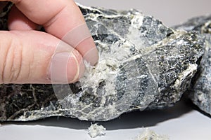 Asbestos mineral fiber in human fingers, close-up