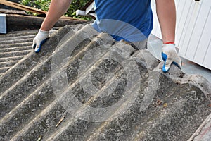 Asbestos removal roofer roof works. House with old, danger asbestos roof tiles repair and renovation.  Risks of Asbestos Roofs,