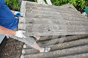 Asbestos removal roofer roof works. House with old, danger asbestos roof tiles repair and renovation.  Risks of Asbestos Roofs,