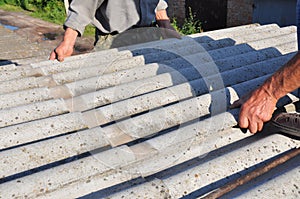 Asbestos removal. Roofers replace damaged asbestos tile. Repair asbestos roof. photo