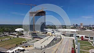 ascending aerial footage of a gorgeous spring landscape with skyscrapers, office buildings, lush green trees and tower cranes