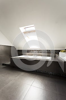 Ascetic attic bathroom with bathtub photo