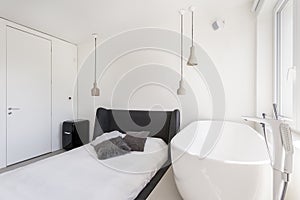 Ascetic bedroom with oval bathtub photo
