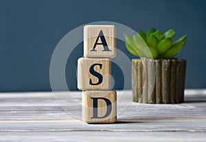 ASD - word on wooden cubes on the background of a cactus