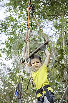 Asean boy hanging rod Tied with ropes and slings background blurry tree