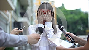 Ashamed businesswoman closing face with hands on press conference, scandal