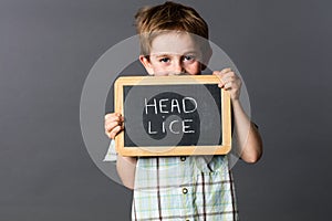 Ashamed preschool boy informing about head lice at school