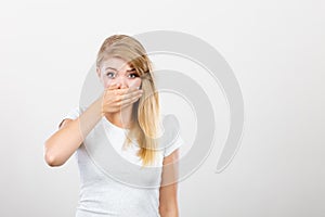 Ashamed woman having hand on mouth