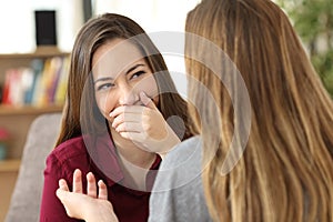 Ashamed woman hiding her smile in a conversation