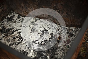 Ashes in the trash can. Burnt paper in the container. Coal from incinerated waste photo