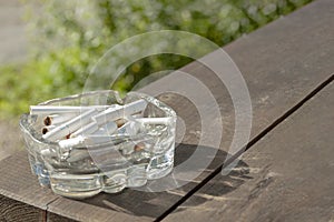 An ashtray with cigarettes is on the table