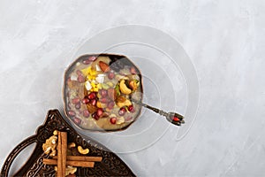 Ashure Dessert in metal bowl on grey background, top view