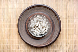 Ashwagandha Whitania somnifera Veg herb capsules on round cla