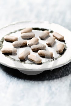 Ashwagandha Withania somnifera tablets. Wooden background.