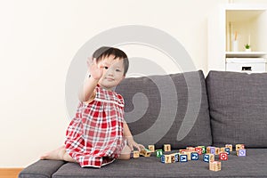 Asia baby girl play toy block and sitting on sofa