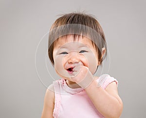 Asia baby girl put finger into mouth