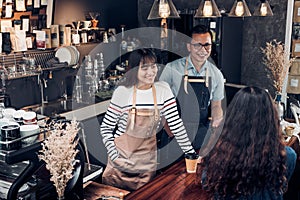 Asia barista waiter and waitress take order from customer in coffee shop,Two cafe owner writing drink order at counter photo