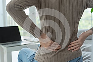 Asia beautiful woman holding her lower back while and suffer from unbearable pain health and problems, chronic back pain, backache