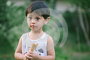 Asia boy he mouth aftertaste from eating chocolate ice cream  or chocolate dessert. A sweet-toothed child eat chocolate. Kid with