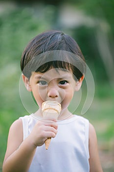 Asia boy he mouth aftertaste from eating chocolate ice cream  or chocolate dessert. A sweet-toothed child eat chocolate. Kid with