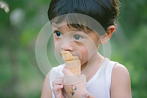 Asia boy he mouth aftertaste from eating chocolate ice cream  or chocolate dessert. A sweet-toothed child eat chocolate. Kid with