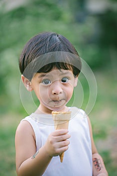 Asia boy he mouth aftertaste from eating chocolate ice cream  or chocolate dessert. A sweet-toothed child eat chocolate. Kid with